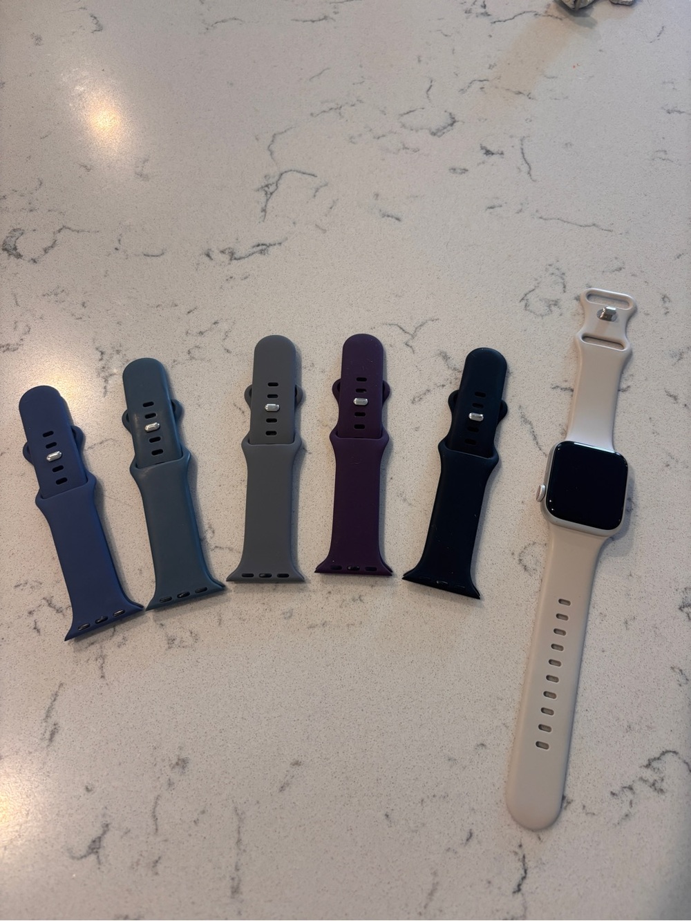 Apple Watch with Beige Band and Five Silicone Replacement Bands
